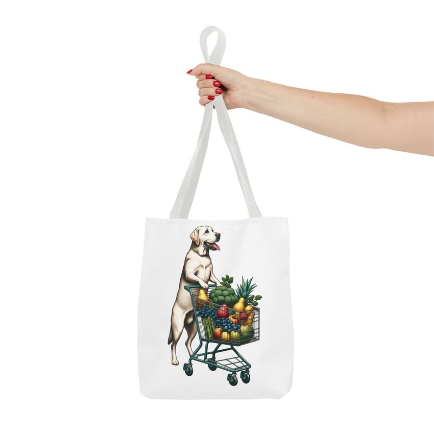 Dog-themed tote bag with a grocery cart of colorful produce, held by red-manicured hand.