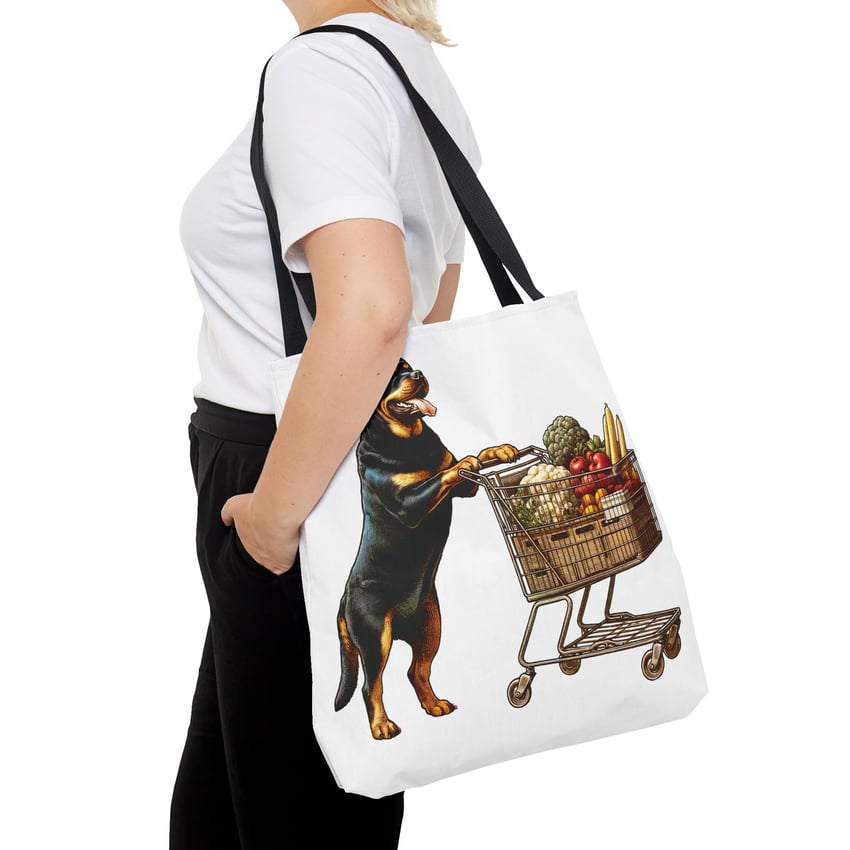 Rottweiler pushing grocery cart on tote bag; colorful, whimsical design, person in casual attire.