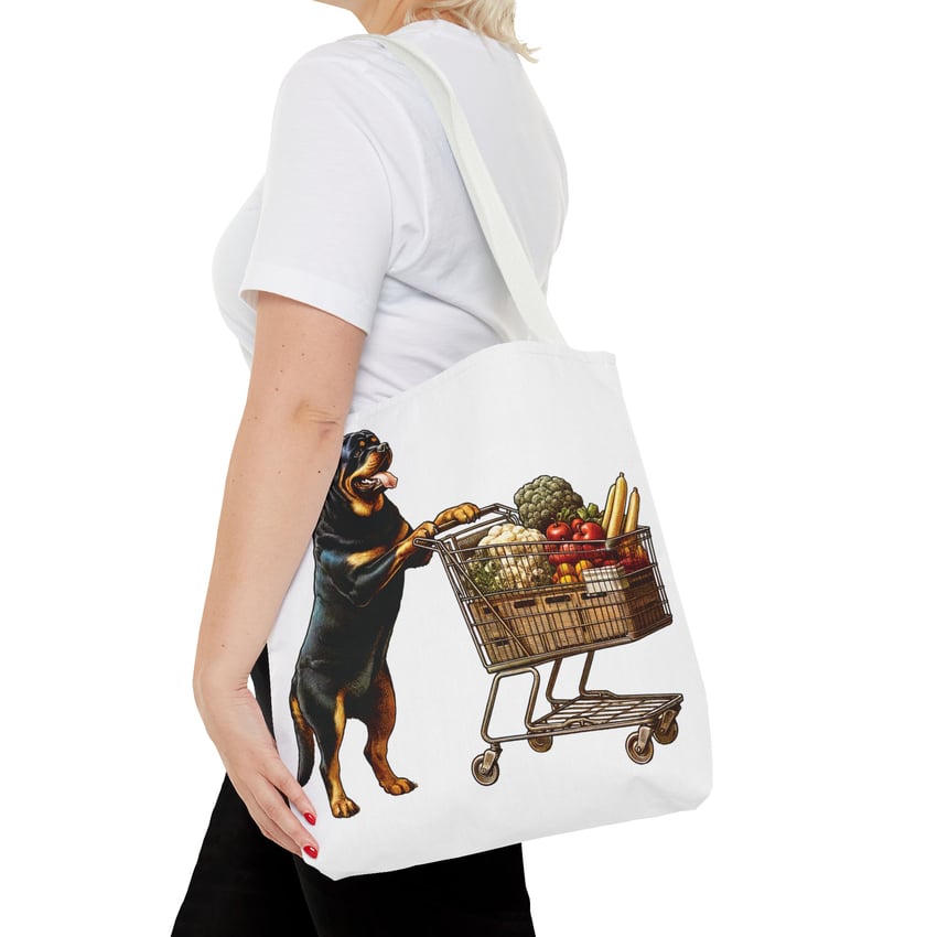 Tote bag with whimsical Rottweiler pushing a shopping cart illustration.