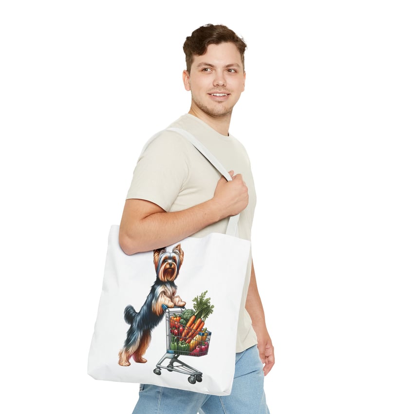 Person with a tote bag featuring a colorful Yorkshire Terrier and groceries, casual style.