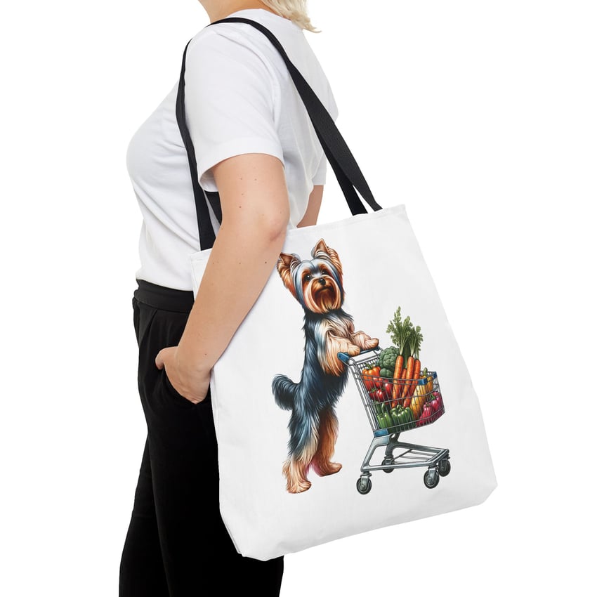 Yorkshire Terrier tote bag with whimsical vegetable shopping design, carried by person in casual outfit.